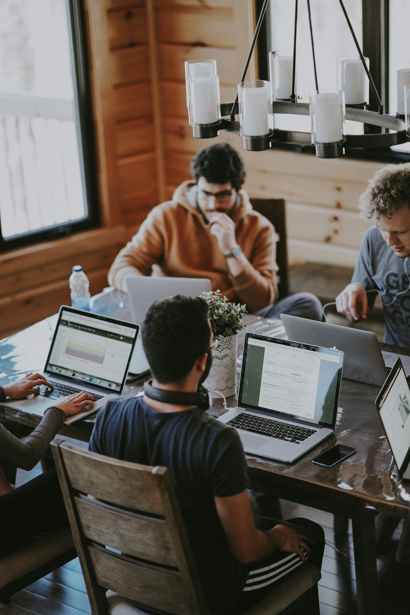 A group of professionals working together with laptops around a table